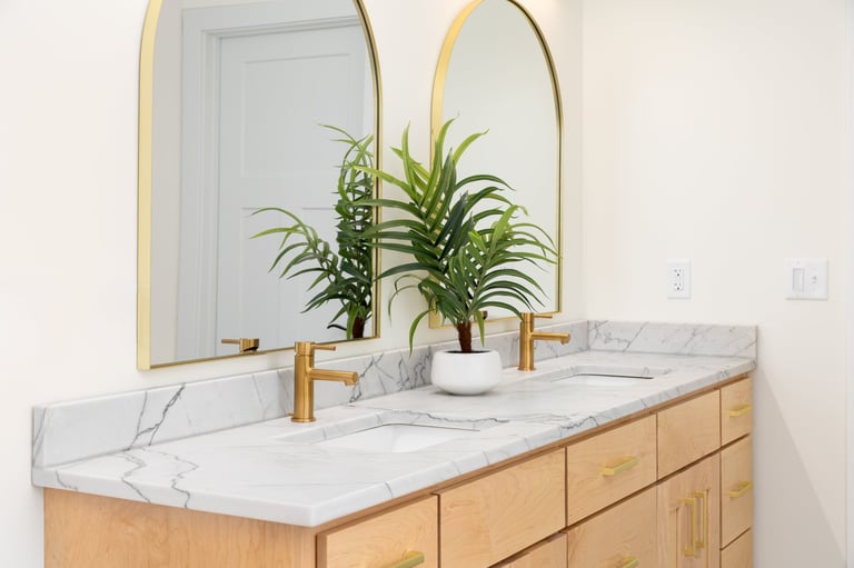 Modern luxury bathroom renovation with marble countertop and gold faucets